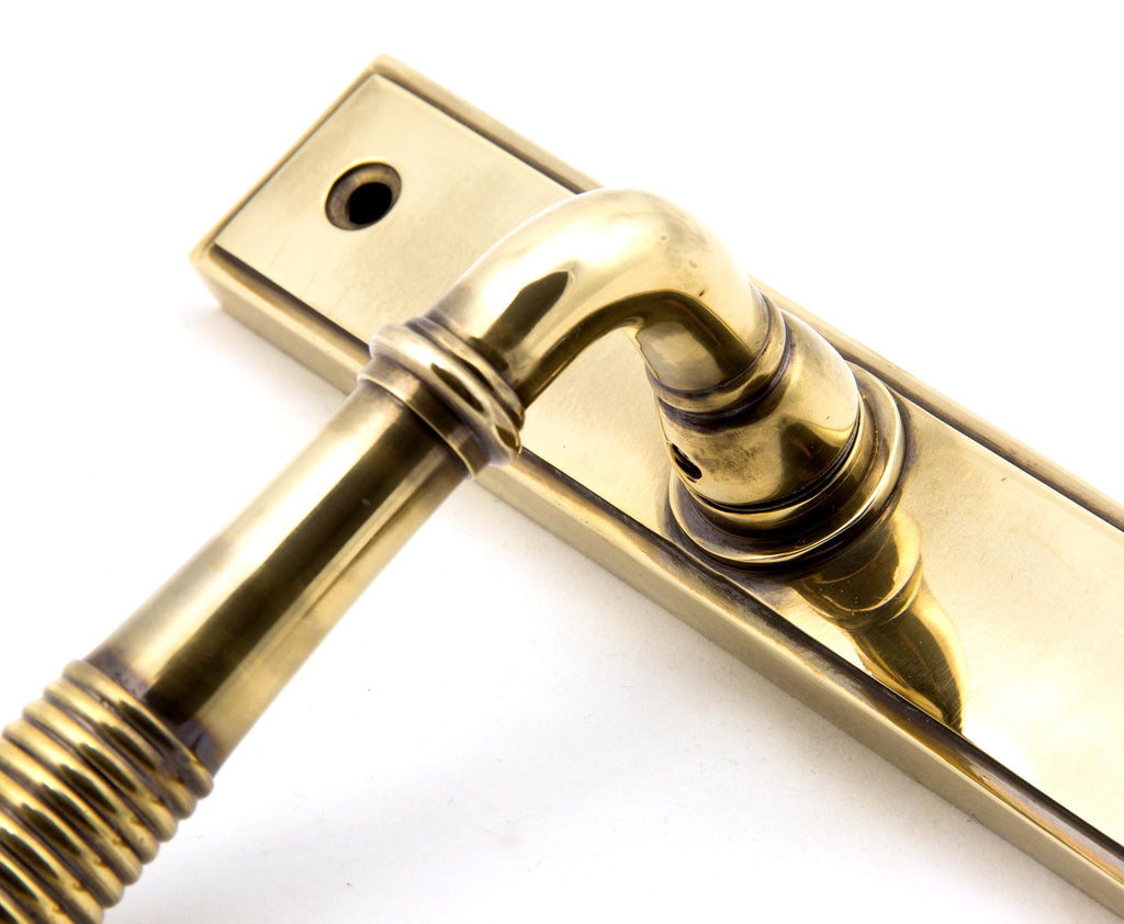 White background image of From The Anvil's Aged Brass Reeded Slimline Lever Espag. Latch Set | From The Anvil