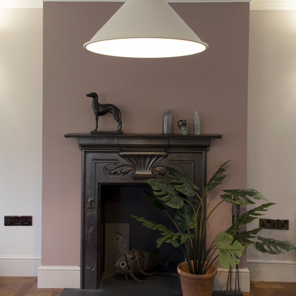 White gloss Hockley pendant light above an ornate fireplace against a pink wall.