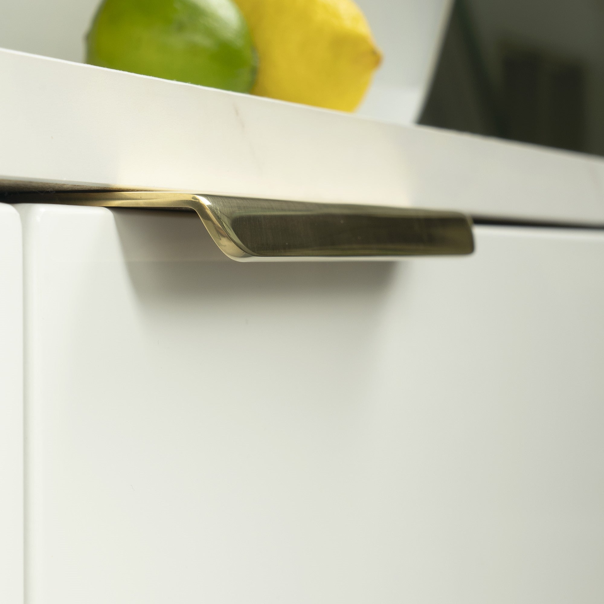 Polished Brass From The Anvil drawer cupboard edge pull on a white cupboard.