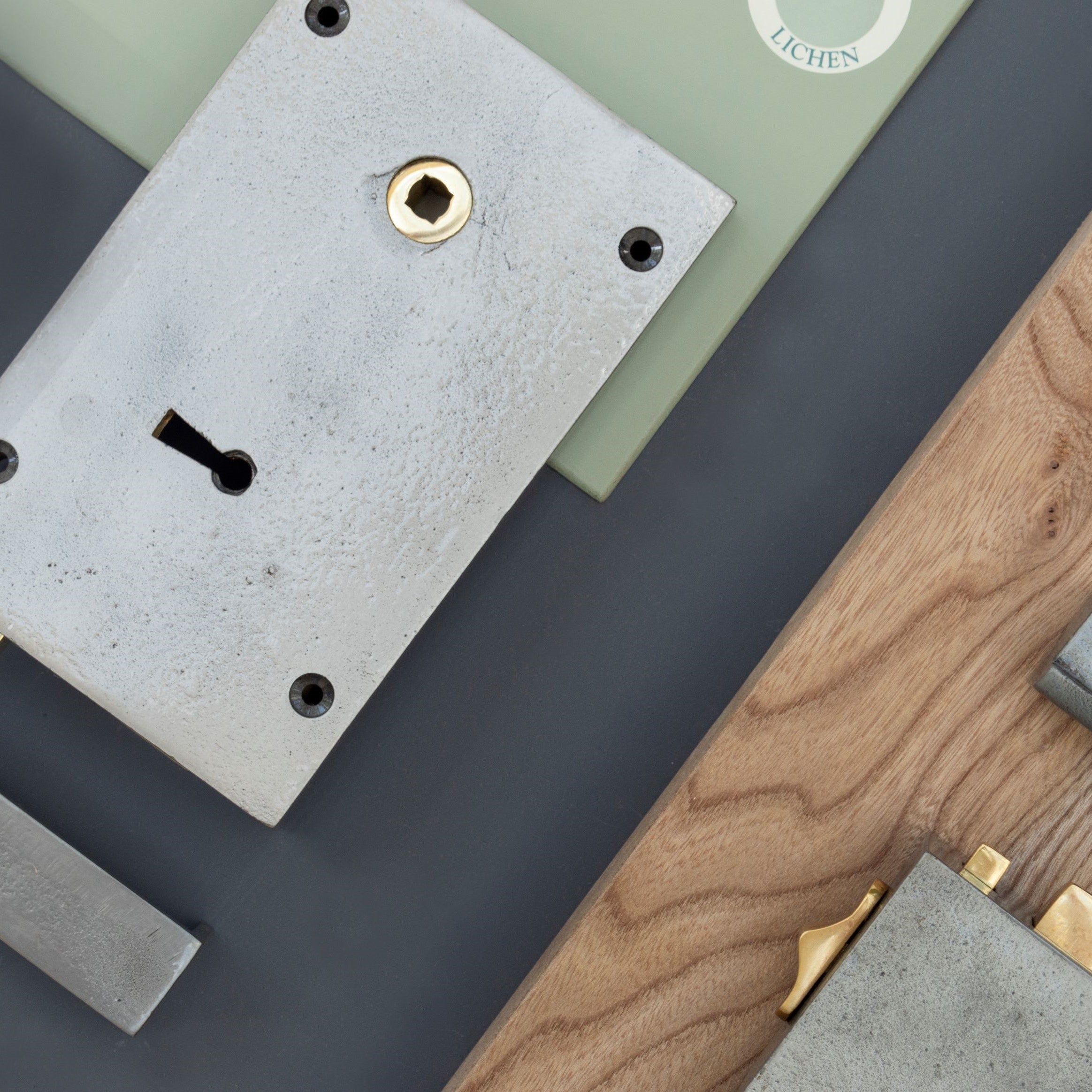 Ironmongery mood board with green, navy & wooden background and 2 iron door locks.