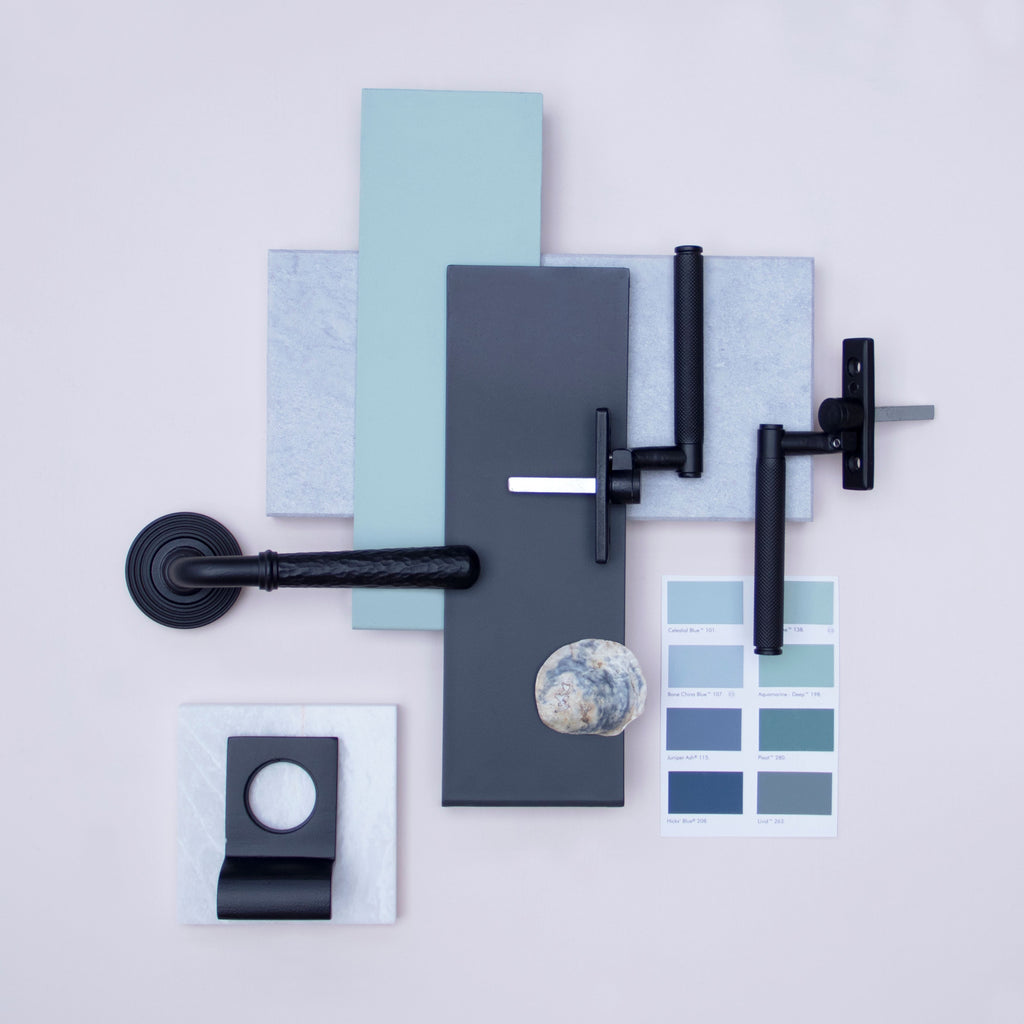 Ironmongery mood board with various blue paint swatches, blue seashell, white marble slabs, and Matt Black door handle, escutcheon and window hardware.