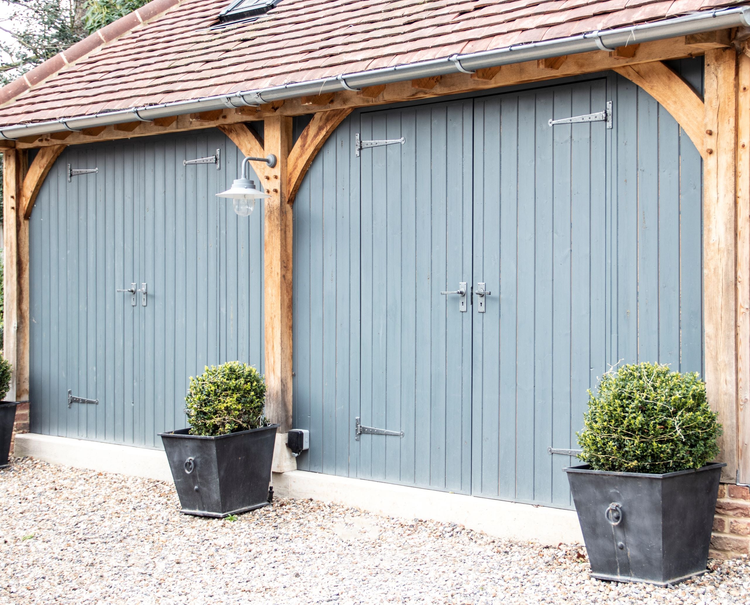 From The Anvil's Pewter Penny End T Hinges and matching lever lock door handles on a blue garage.