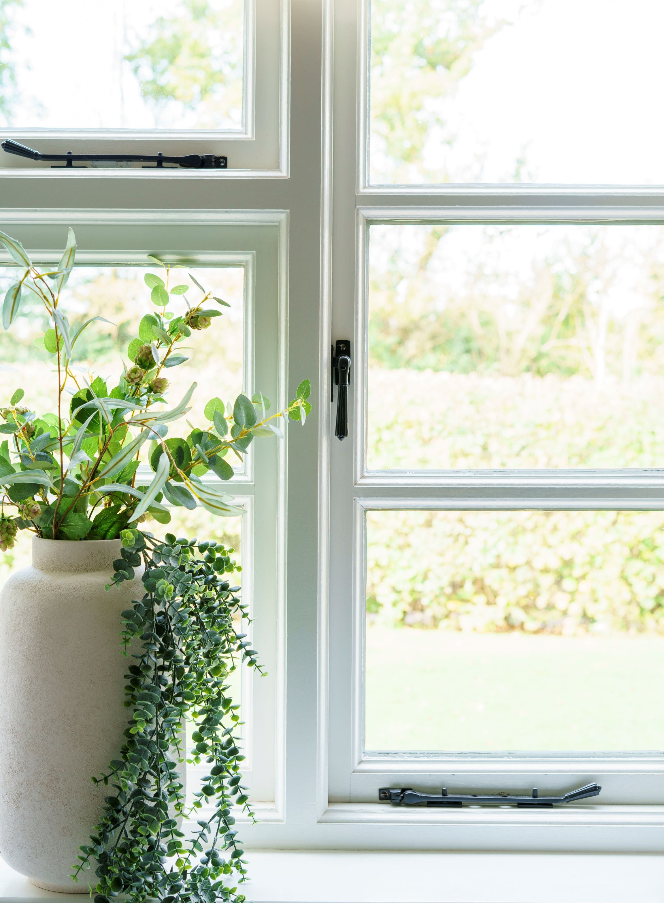 From The Anvil's Aged Bronze window hardware (window stays and handles) on a white uPVC window.