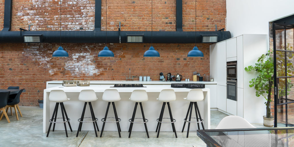 Modern industrial studio with a row of bright blue Harborne ceiling pendant lights.