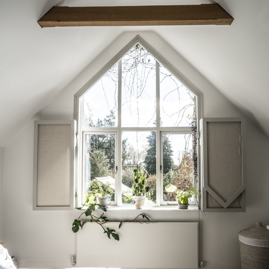Large white, pointed window with shutters with From The Anvil's Pewter window handles and window stays.