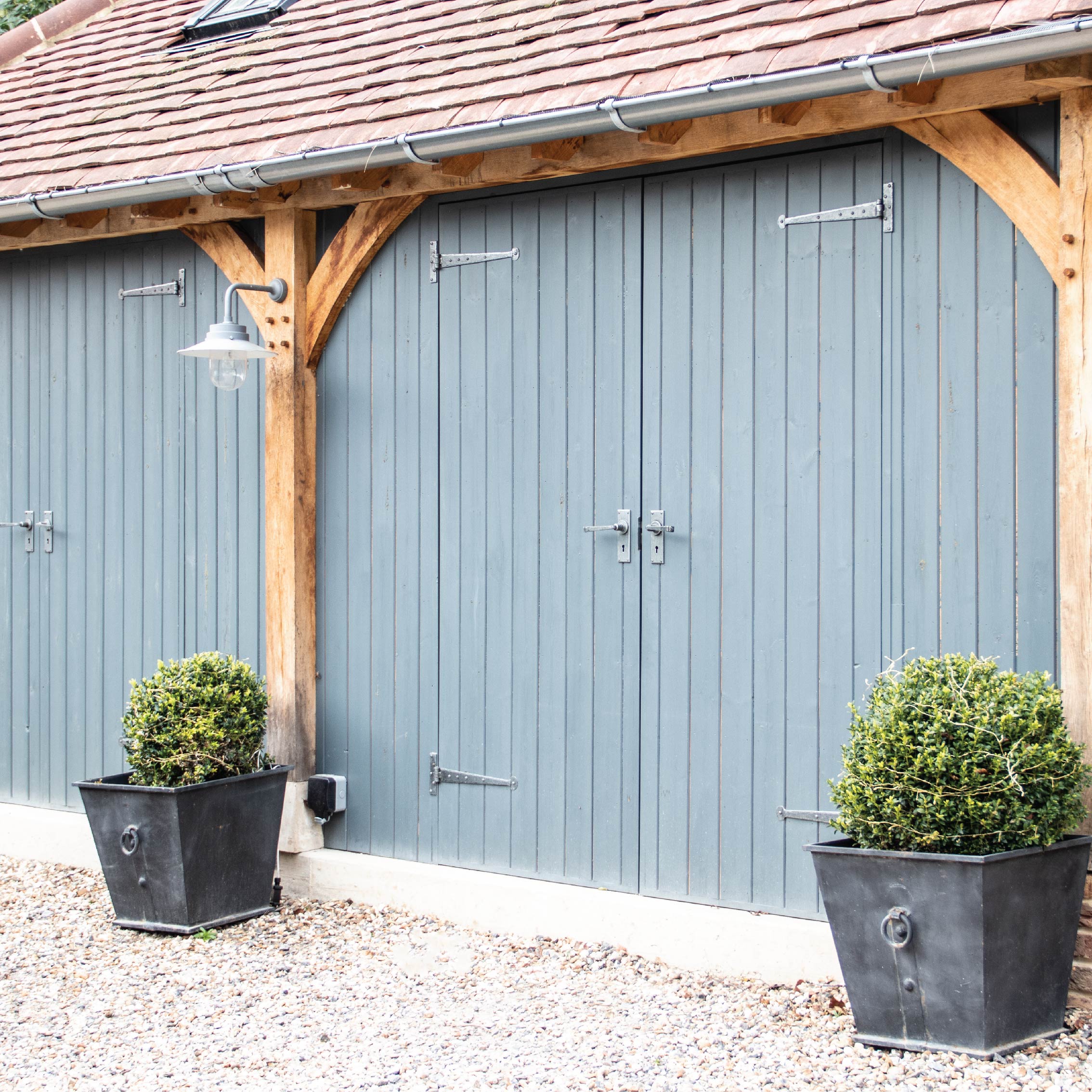 From The Anvil's Pewter Penny End T Hinges and matching lever lock door handles on a blue garage.