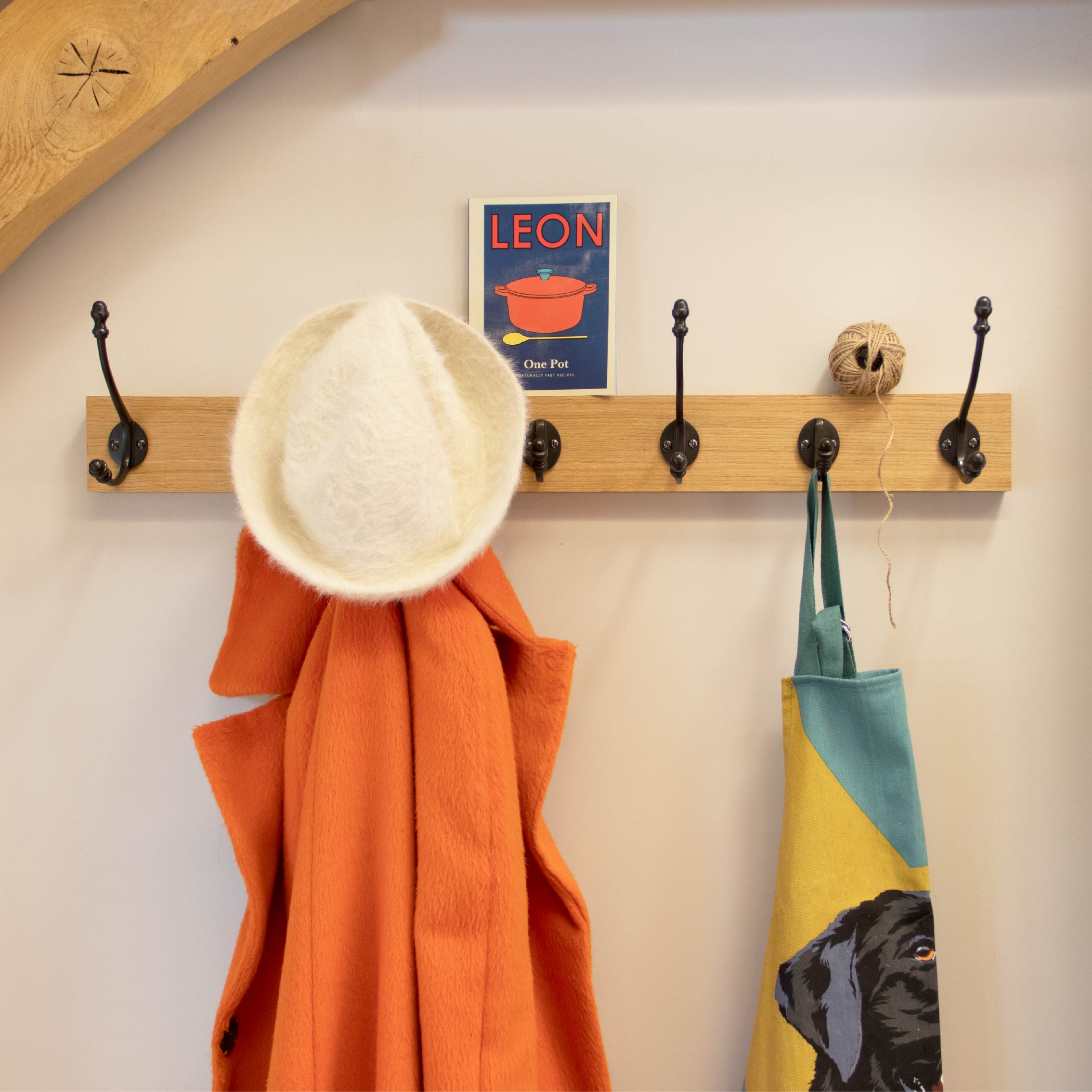 From The Anvil's Black hat and coat hooks on a wooden coat rack.
