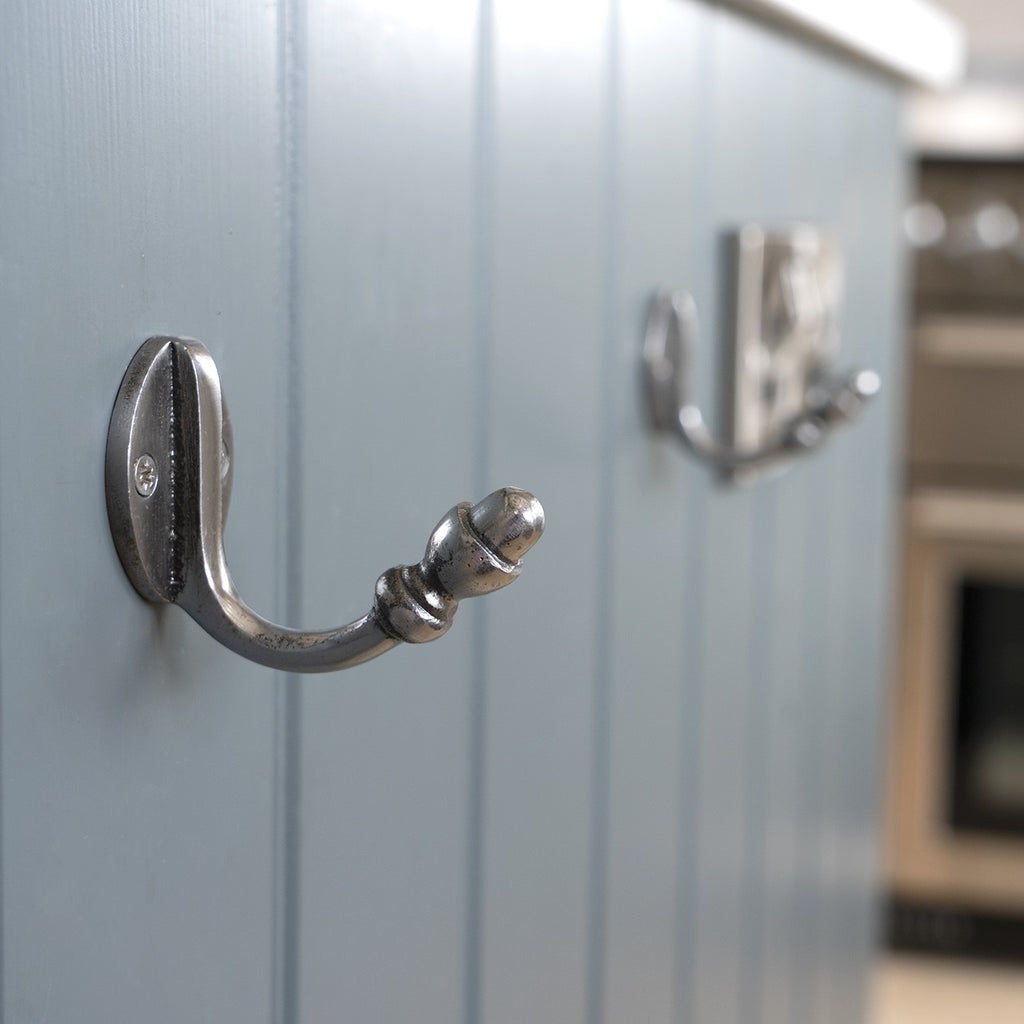 Blue painted wooden panelling with From The Anvil Pewter hooks attached.