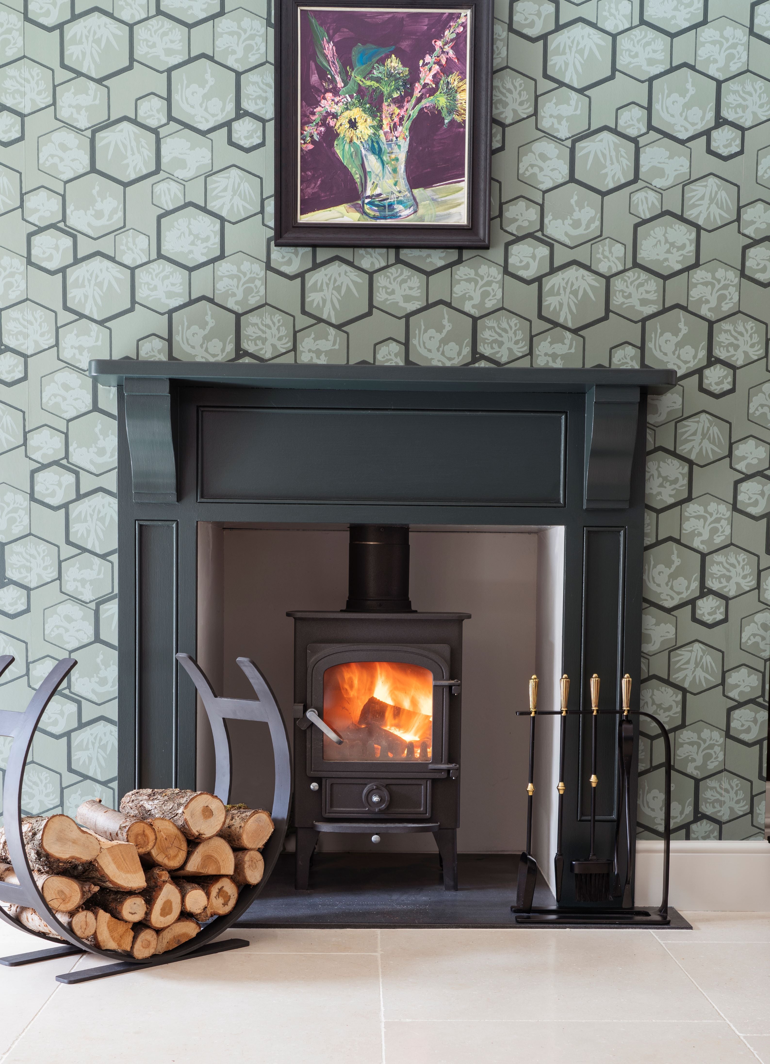 From The Anvil's Matt Black Curved log holder and Hinton companion set in front of a lit log burner.