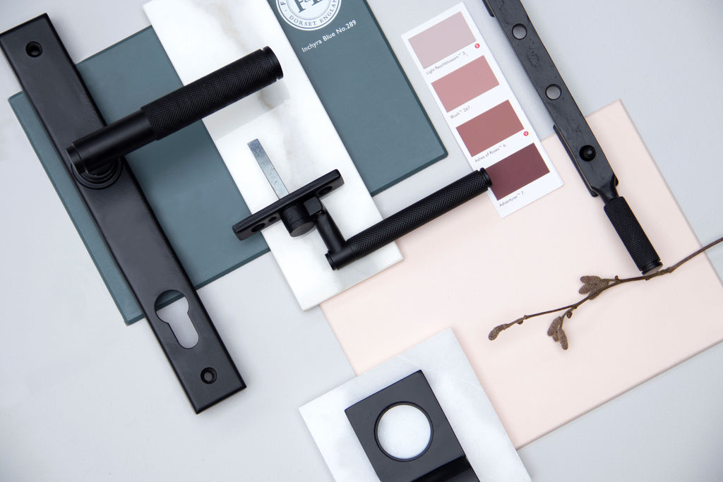 Ironmongery mood board with pink & blue paint swatches, white marble slabs, and Matt Black door handle, window hardware and escutcheon.