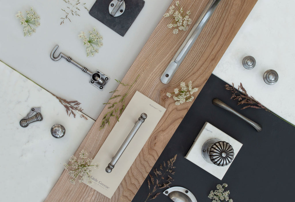 Ironmongery mood board with dried flowers, wood, marble & navy background, and Pewter door knobs, cabinet knobs, escutcheon, cabin hook & pull handles
