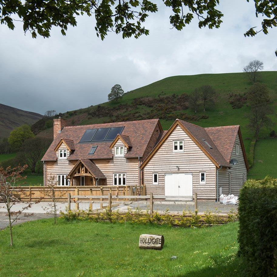 Exterior shot of a New Rustic property with solar panels and a large green garden.