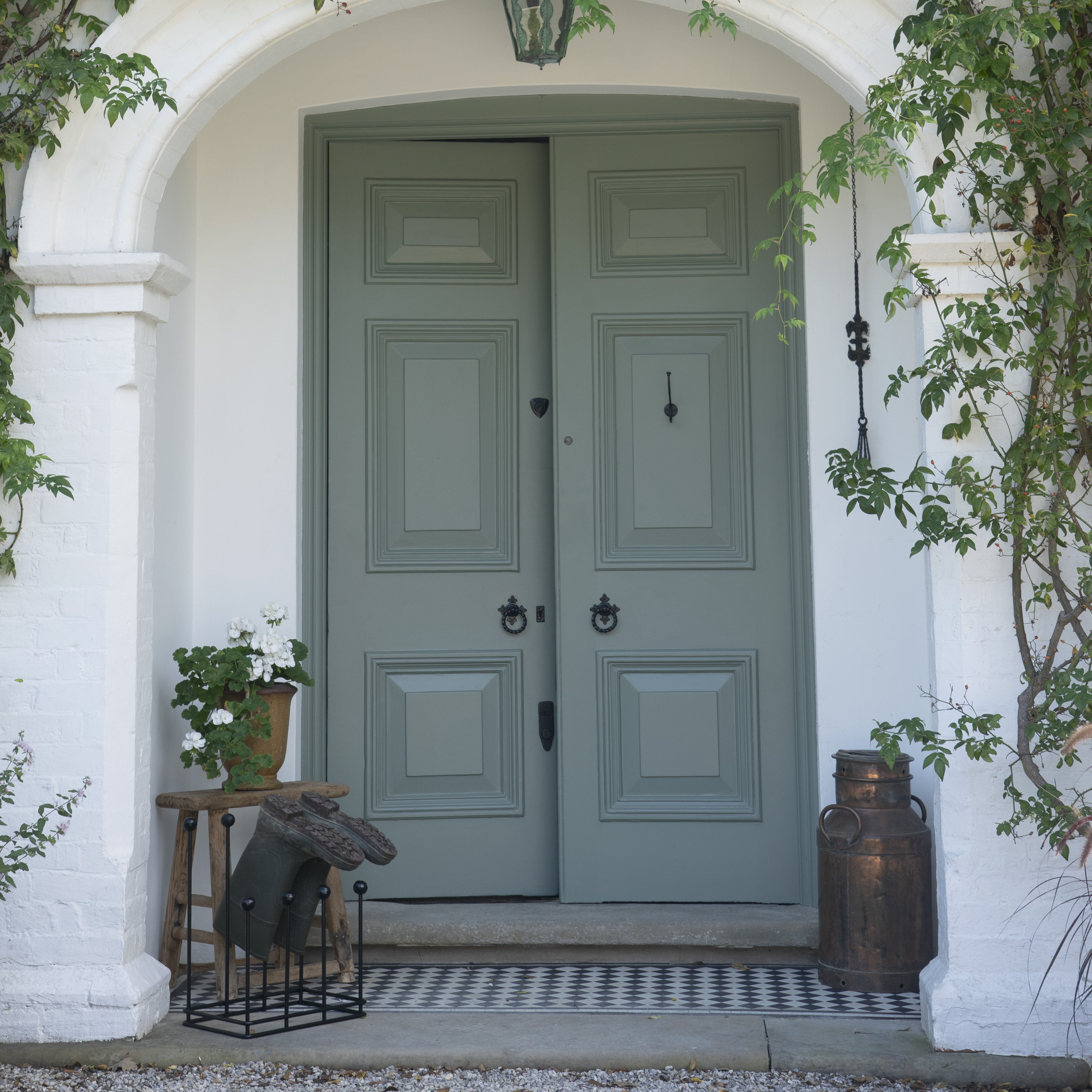 Black door handles on a blue door with a Black boot rack outside.