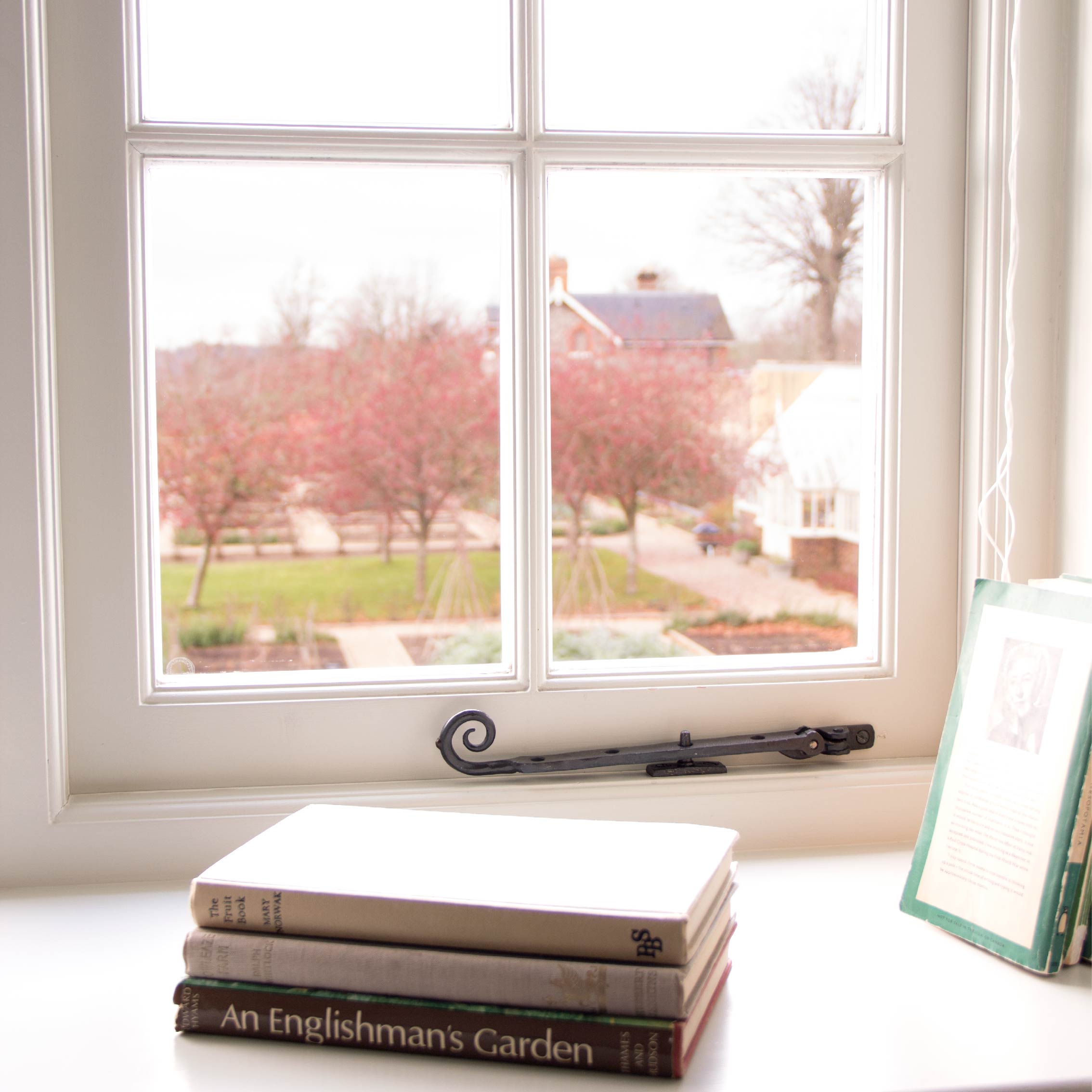 From The Anvil's Black Monkeytail window stay on a white wooden window frame